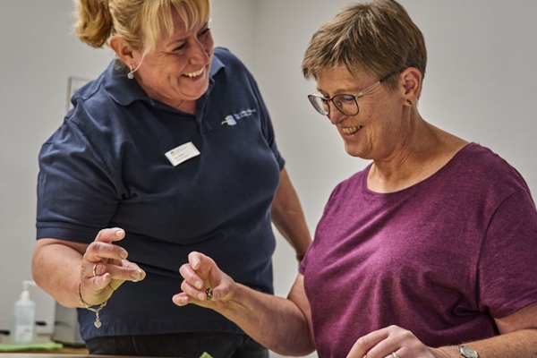 Therapeutin mit einer Rehabilitandin bei Übungen zur Feinmotorik Therapeutin mit einer Rehabilitandin bei Übungen zur Feinmotorik